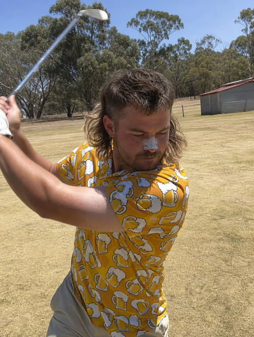 Aussie golfer with a mullet mid-swing in the Golden Hour beer print polo